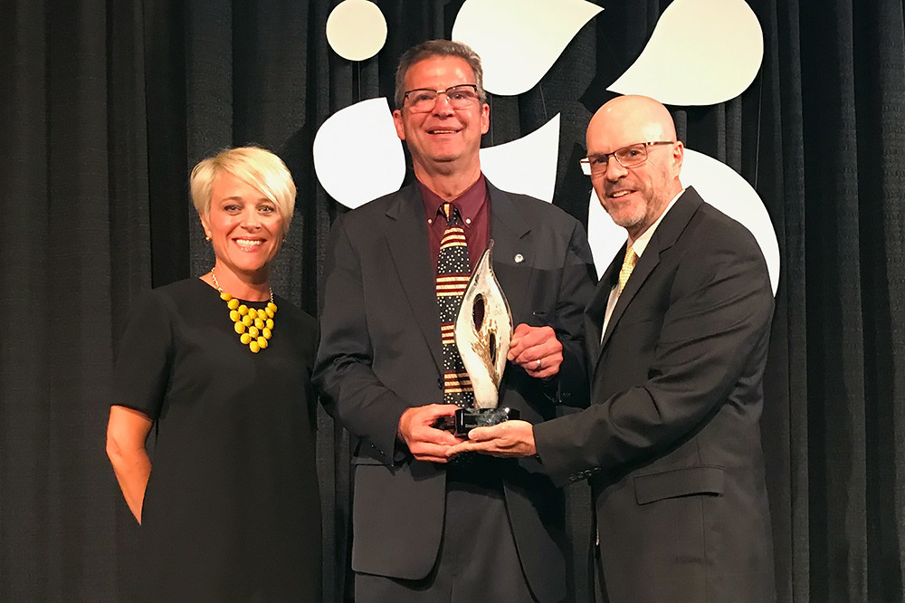 Stephen Kleinsmith, middle, is presented the Superintendent of the Year award by Missouri Association of School Administrators Executive Director Doug Hayter. Also pictured is Trish Oppeau of the Missouri Securities Investment Program.