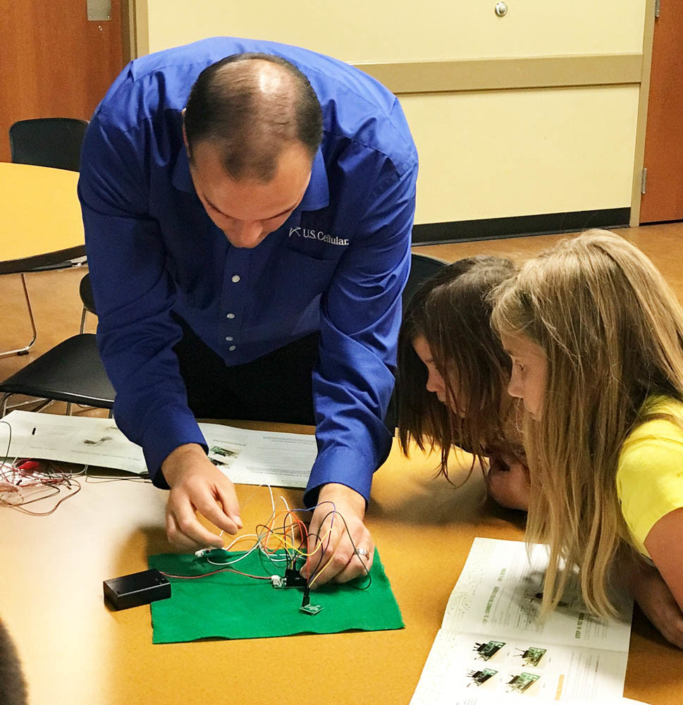 Science in Action
U.S. Cellular Store Manager Nathan Piper shows Greene County 4-H Club students Kodi Burdick and Kaitlyn Darling how to build a fitness-tracking device as part of the National 4-H Council’s National Youth Science Day on Oct. 3. Several other U.S. Cellular associates also volunteered as part of the company’s commitment to STEM education.