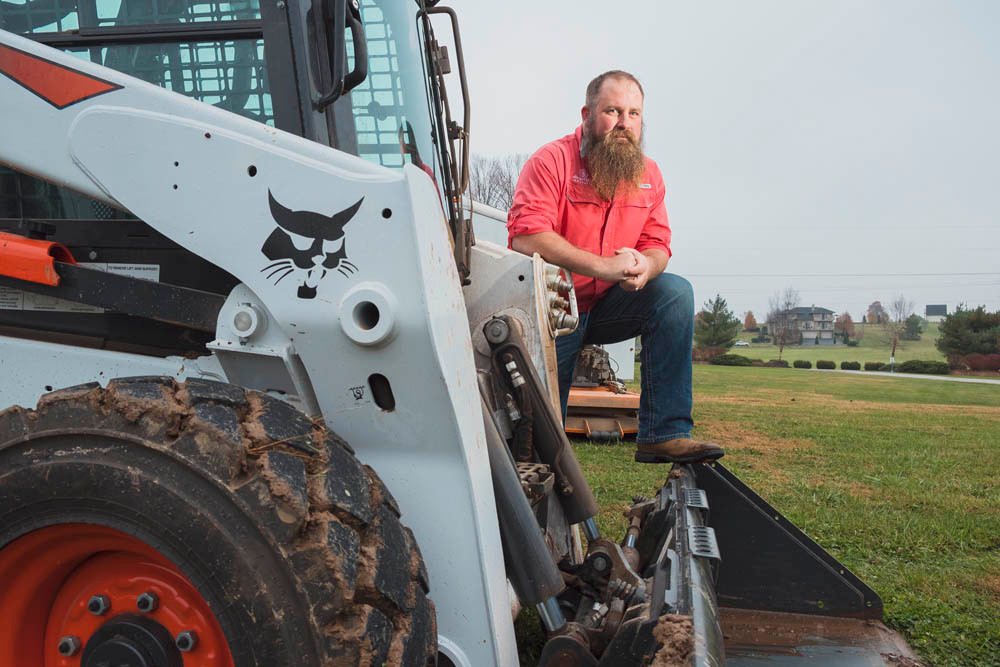 GOT YOUR BACK: Elite Outdoor Innovations owner Clint Harlan’s Bobcat skid steer is part of the equipment he purchased with a Small Business Administration-backed loan.