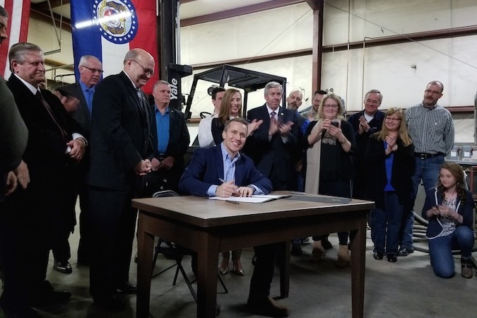Gov. Eric Greitens ceremonially signs right-to-work legislation into law at a vacant Springfield plant.