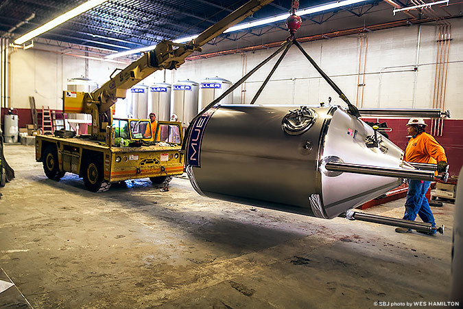 1,000 GALLONS: Workers install a new fermenting tank at Springfield Brewing Co.