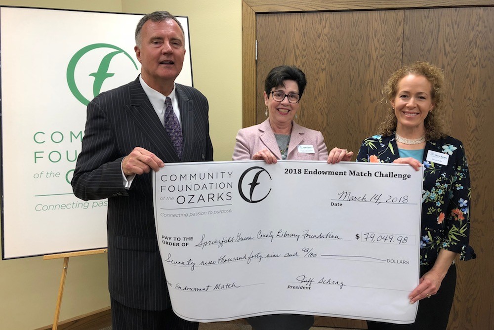 Community Foundation of the Ozarks President Brian Fogle presents an endowment check to Executive Director Regina Greer Cooper and Development Director Melissa Adler of the Springfield-Greene County Library District.