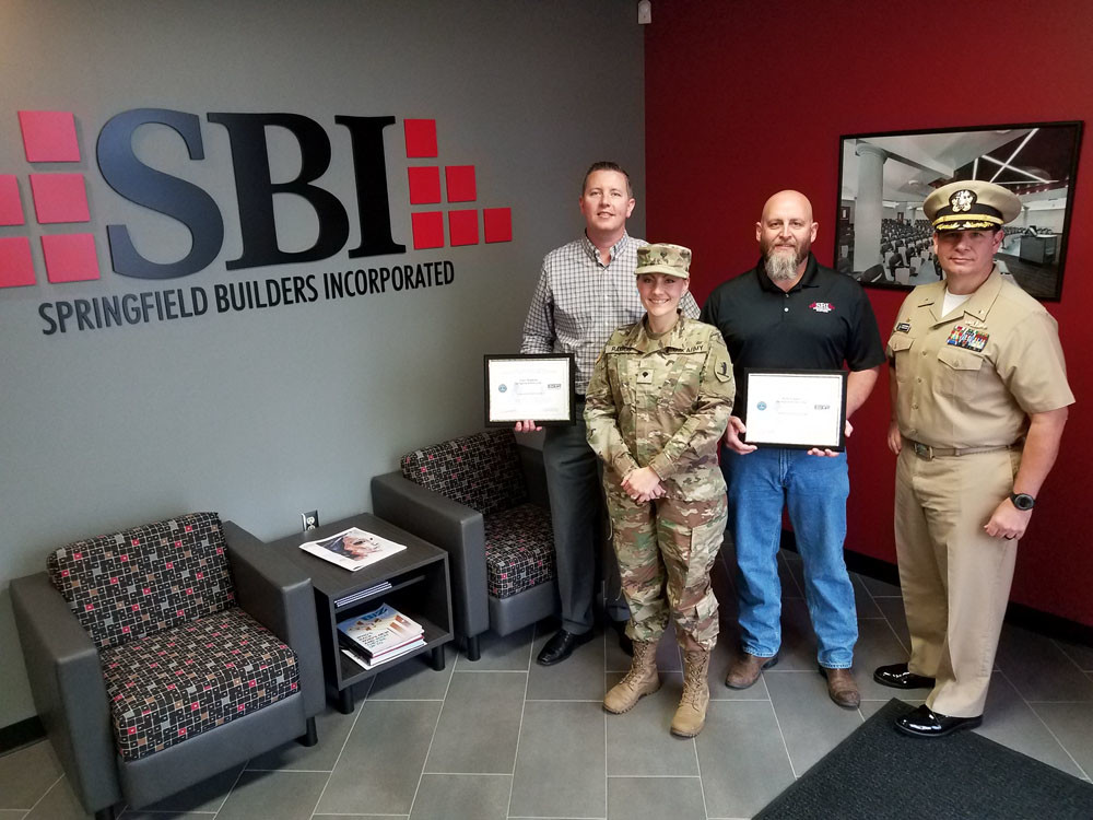 Employer Honors
Navy Cmdr. Donald Wingard, far right, presents the Patriot Award to Springfield Builders Inc. Vice President Tony Hopkins, far left, and President Kirk Looney for their support of Army National Guard work by Spc. Stacie Ramos, a project estimator for SBI. The award recognizes entities that support employees serving in the National Guard or Reserve.