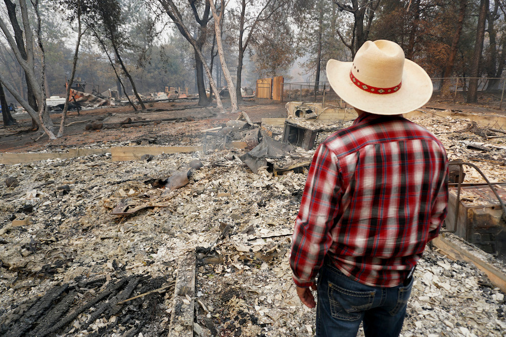 A man stands before ashes left behind by California’s Camp Fire in a picture provided by Convoy of Hope. Pictured is the senior pastor of the First Assembly of God in Paradise, California, who lost his church and home in the fire.