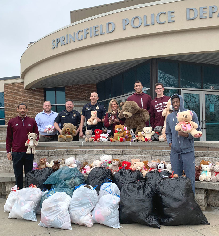 SHARE THE BEAR
Representatives from Old Missouri Bank, along with Missouri State University basketball players and coach Dana Ford, far left, distribute hundreds of new teddy bears to the Springfield Police Department on Jan. 31. Through the bank’s Share the Bear campaign, law enforcement will gift the bears to local children during crisis situations. The stuffed animals were tossed on the court at halftime of this year’s Share the Bear game on Jan. 11 and collected by OMB officials.