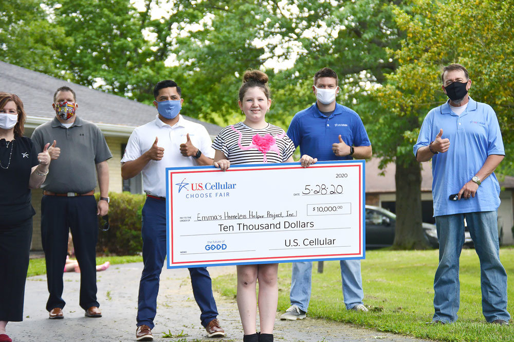 HOMELESS HELPER
U.S. Cellular associates stand behind Marshfield youth Emma Sandbothe, a recipient of the wireless company’s The Future of Good program and a $10,000 prize. The 9-year-old was surprised with a celebratory parade past her home May 28. U.S. Cellular is raising awareness for youth causes and increasing their impact through financial contributions. Sandbothe was one of five youth selected, out of thousands nationwide, for her work starting Emma’s Homeless Helper Project. Through donations, Sandbothe collects hygiene and nonperishable food items, plus clothing, to provide to domestic violence and homeless shelters. To date, Emma’s Homeless Helper Project has donated nearly 500 hygiene kits, 100 food kits  and 300 pairs of socks.