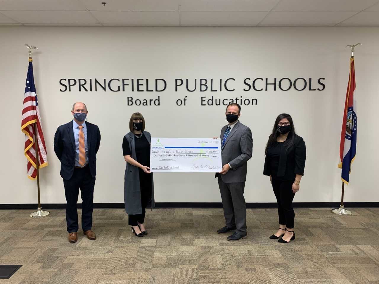 SPS Superintendent John Jungmann, second from right, accepts a ceremonial check from foundation officials, from left, Stephen Gintz, Natalie Murdock and Tina Pham.