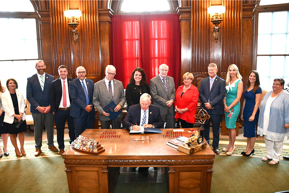 'CLIFF EFFECT'
Gov. Mike Parson, seated, on July 14 signs House Bill 432 into law. The legislation supported by Springfield Rep. Crystal Quade, second from right, includes a provision addressing the “cliff effect,” a term referring to a disproportionate loss in government assistance when a person receives a pay raise at work. The provision creates a pilot program in Greene and Christian counties to taper public benefits so that recipients will not lose them when they reach certain income levels.