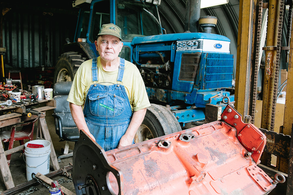 Lane Baxter of Rogersville tunes up an older tractor engine in his shop. Most new equipment requires a dealer's diagnosis to repair.