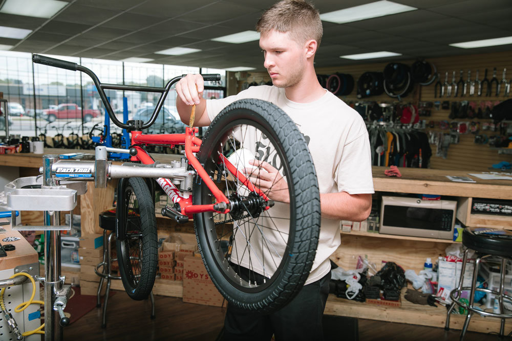 Red's BMX LLC employees Mason Busch assembles a bicycle as part of a newly arrived shipment of Sunday Bikes at the South Campbell Avenue shop.