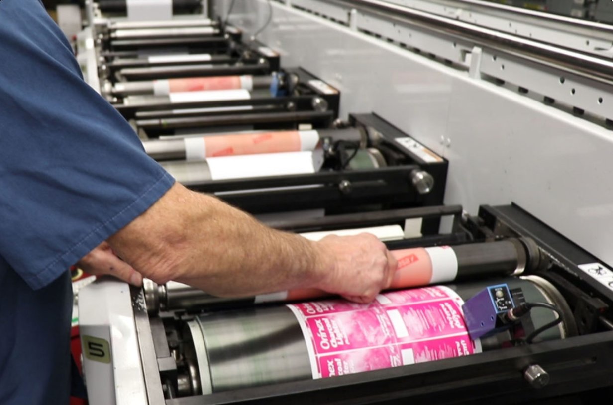An Ample Labels employee transfers ink as part of the labeling process.