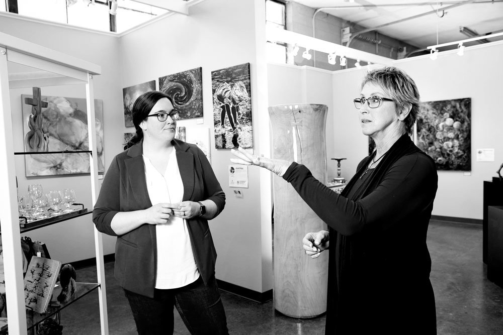 GALLERY HOP: Leslie Forrester, left, checks in with glass artist Cheryl Vowels of SRAC's Fresh Gallery, located in Missouri State University's Brick City.