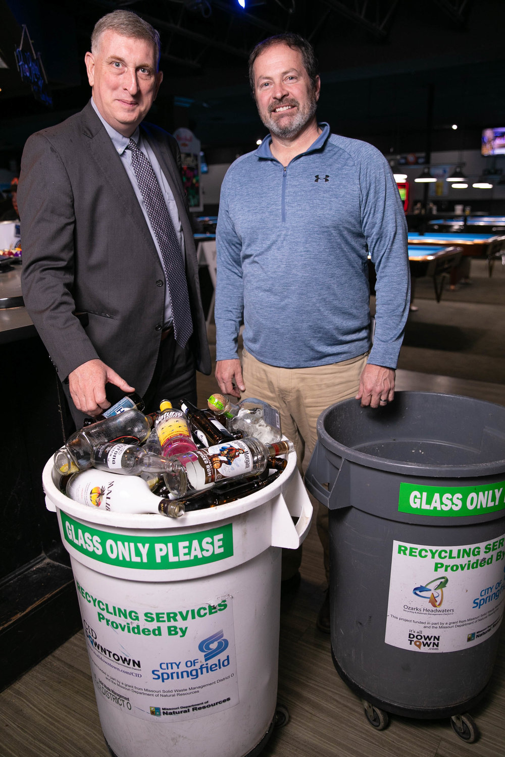 Rusty Worley, left, collects a 35-gallon bin of bottles from Richard Vance, co-owner of Billiards.