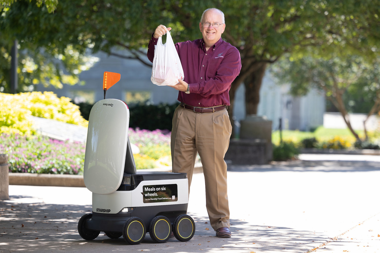 MSU President Clif Smart demonstrates the Starship Technologies delivery system.