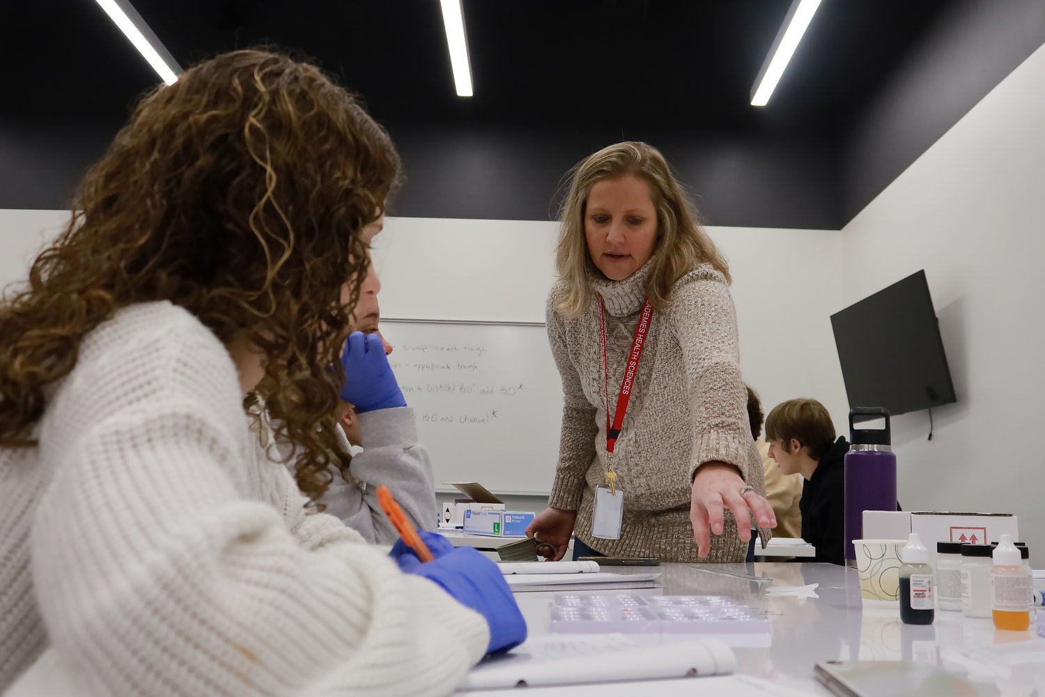 IN THE LAB: Instructor Joanna Throckmorton assists students during a toxicology lab class at the Ozark Innovation Center as part of the school district's health sciences academy.