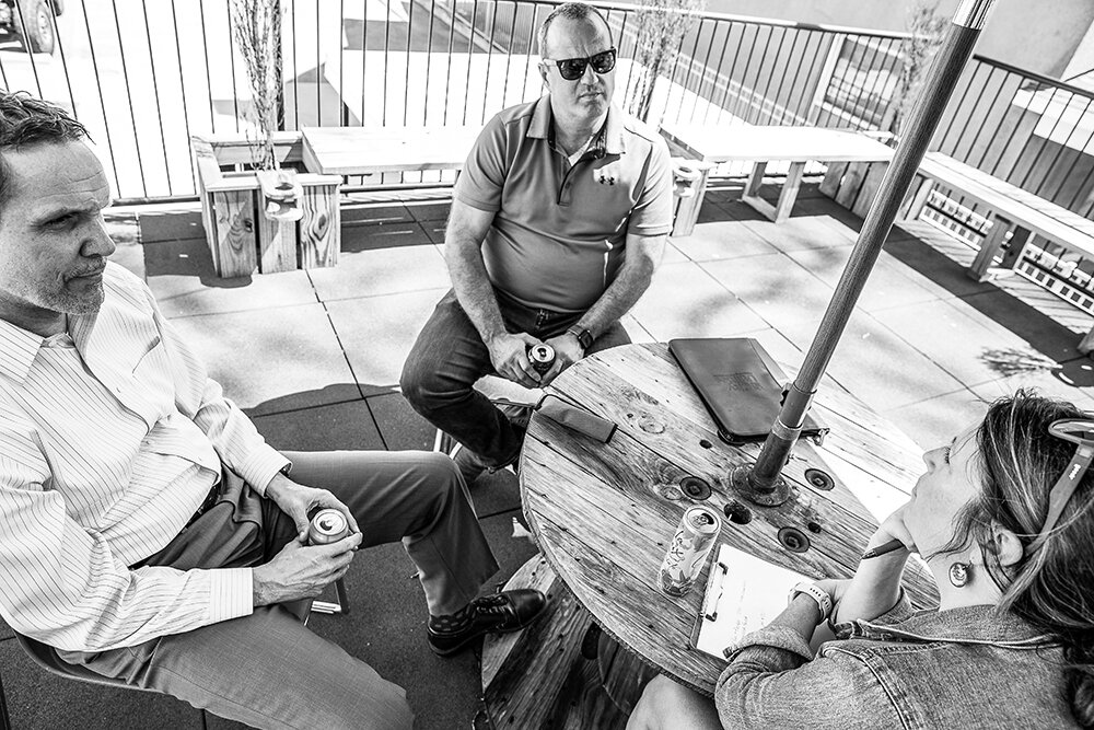 UNDER THE SUN: An 80-degree afternoon calls for an afternoon meeting — this one's a chat with City Utilities officials Daniel Hedrick, left, and Steve Stodden.