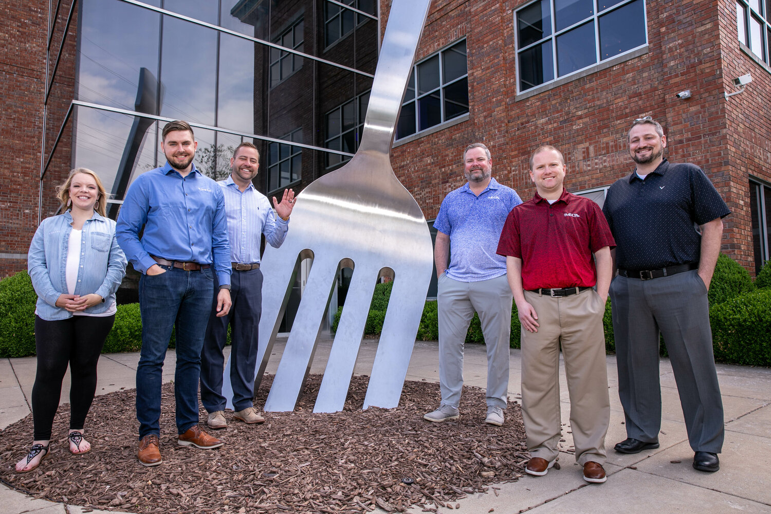 Kinetic Design leaders, from left, Abbye Bobbett, Griffin Bobbett and Adam Kreher stand with SMB partners Jacob Sanders, Matthew Blackwell and Chris Myers at the building the companies purchased together.