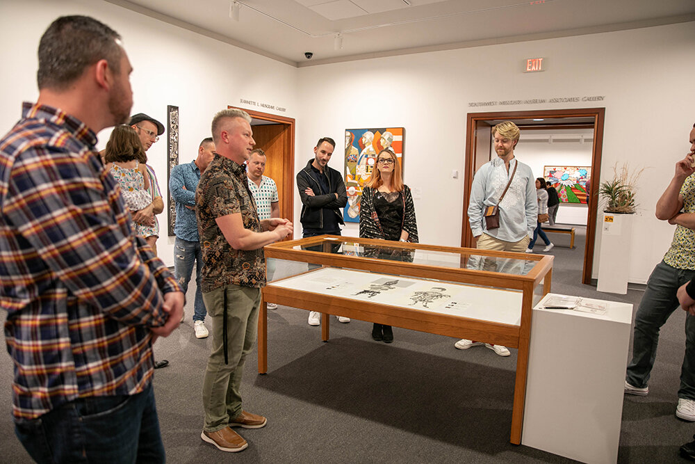 Springfield Art Museum's Joshua Best leads members of 417 Out And About on a tour of Art in Bloom, a museum exhibit showcasing floral and textile artists. Best is also a member of the group.